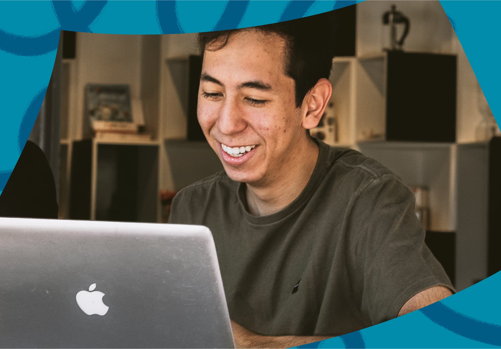 Smiling man sitting in front of a laptop